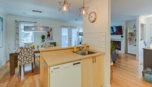 cocina y sala de estar con fregadero y reloj en Condo Entre Ville et Nature 2, en Magog-Orford