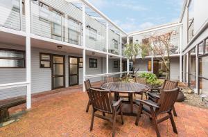 een patio met een tafel en stoelen voor een gebouw bij Queen Street Studios in Richmond