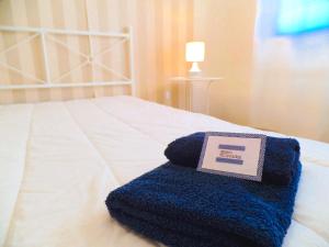 a blue towel on a bed with a sign on it at Pátio das Cavadas Apartment in Rio Tinto