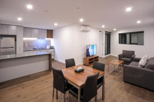 a kitchen and a living room with a table and chairs at Flagstaff Green Apartments in Melbourne