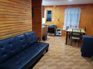 a living room with a couch and a table at Cabaña en Curacautin in Curacautín