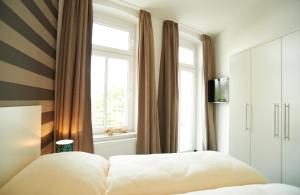 Schlafzimmer mit einem Bett und einem Fenster in der Unterkunft Apartment Eisberg 3 mit schöner Balkonterrasse in Norderney