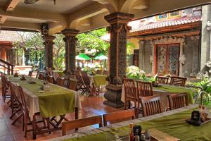 um restaurante com mesas e cadeiras num edifício em Masainn Hotel Kuta em Kuta