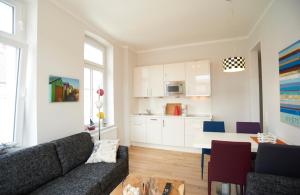 a living room with a couch and a kitchen at Apartment Eisberg 4 mit Balkon in Norderney