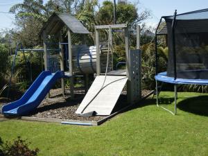 a playground with a slide in a yard at Buller Bridge Motel in Westport