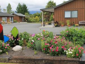 a garden of flowers in front of a building at Buller Bridge Motel in Westport