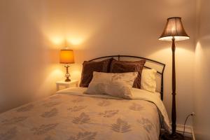 1 dormitorio con 1 cama con almohadas y lámpara en The Secret Garden Treehouse, en North Vancouver