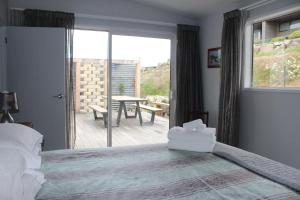 um quarto com uma cama e vista para um pátio em The Mackenzie Apartments em Lake Tekapo