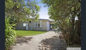 a house with a gravel driveway in front of it at Relax at Tranquil Rye short walk to beach & shops in Rye