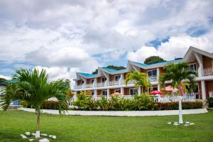 a large building with palm trees in front of it at Hotel & Resort Villa del Sol in Tumaco