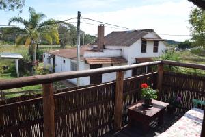 a balcony with a wooden fence and a table with flowers at Cabaña Picaflores in Barra de Valizas