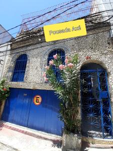 un edificio con puertas azules y flores delante de él en Pousada Axé, en Salvador