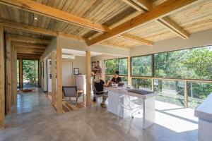 two people sitting at a kitchen island in a room with windows at Kariega Game Reserve Main Lodge in Kenton on Sea +11 photos