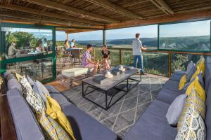 a group of people standing on a balcony with a table at Kariega Game Reserve Main Lodge in Kenton on Sea