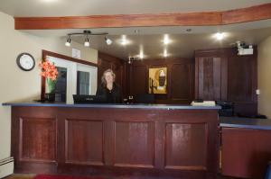 Una donna in piedi in un bar in un'aula di tribunale di Canadas Best Value Inn and Suites Fernie a Fernie