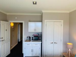 a kitchen with white cabinets and a microwave at Tekapo Heights in Lake Tekapo