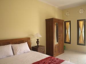 a bedroom with a bed and a cabinet and a lamp at D'SARI UNDISAN Houses in Bangli