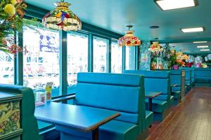a restaurant with blue chairs and tables and windows at Hotel New Ohte in Hakodate