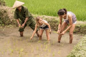 two women and a girl playing in a paddy field at Four Seasons Resort Bali at Sayan in Ubud