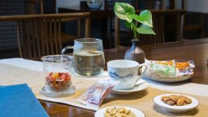 einen Tisch mit Speisen und Getränken auf dem Tisch in der Unterkunft Floral Hotel ·Hefu Hotel (Hangzhou West Lake) in Hangzhou