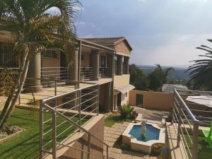 una casa con piscina frente a ella en Aquila Guest House en Pretoria
