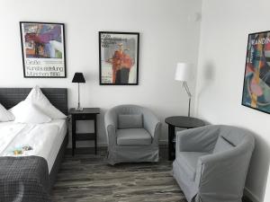 a hotel room with a bed and a chair and a bed and a chair istg at Hotel Nymphenburg City - München in Munich