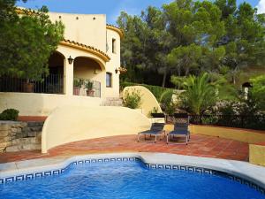 una casa con piscina frente a una casa en Casa Kirbo, en Altea