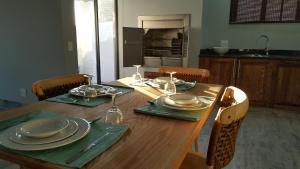 a wooden table with plates and glasses on top of it at Sunset Lagoon in Port Nolloth