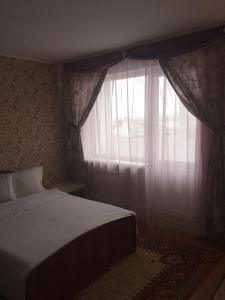 トムスクにあるVictoriaHotel on Musy Dzhalilyaのベッドルーム1室(ベッド1台付)、窓(カーテン付)