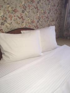 トムスクにあるVictoriaHotel on Musy Dzhalilyaのベッドルーム(白いシーツと枕付)