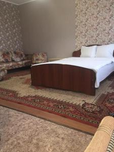 トムスクにあるVictoriaHotel on Musy Dzhalilyaのベッドルーム(大型ベッド1台、ソファ付)