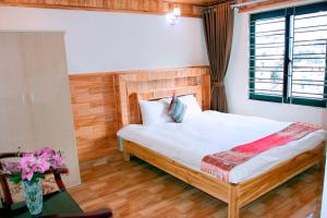 Schlafzimmer mit einem großen Bett mit einem Kopfteil aus Holz in der Unterkunft Tạo Phượng Sa Pa Hotel in Sa Pa