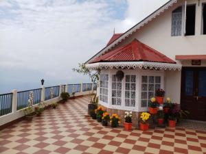 una casa con suelo a cuadros y porche con flores en Yashita Homestay en Darjeeling