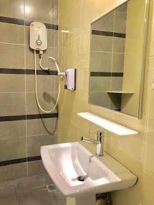 a bathroom with a sink and a shower at De Champs Hotel in Kuantan