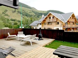 a deck with chairs and a table and a house at Boost Your Immo Les Deux Alpes Chalet Gaspard 184 in Les Deux Alpes