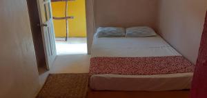 a small bedroom with two beds in a room at Lola Atlachinolli in Sayulita