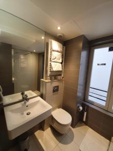 a bathroom with a sink and a toilet and a window at Hôtel De La Herse d'Or in Paris +47 photos