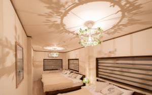 大阪的住宿－AGURIHOME Hayashiji，一间卧室配有两张床和吊灯。