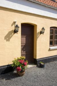 a building with a door and two pots of flowers at Munkebjerg Bed & Breakfast in Børkop