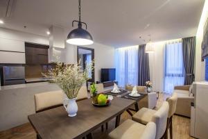 a dining room and living room with a table and chairs at Parosand Hanoi Hotel in Hanoi