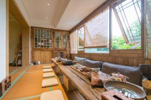 Großes Zimmer mit einem langen Holztisch und Bänken. in der Unterkunft Zen Tea House Seven Stars Park in Guilin