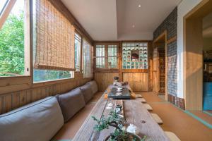 a living room with a long couch and windows at Zen Tea House Seven Stars Park in Guilin