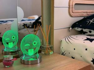 a table with two green alien lamps on it at Apartament Smiley in Sighişoara