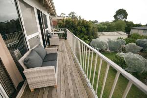 a balcony with a couch and chairs on a porch at Iris Views - Dromana in Dromana