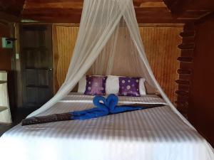 a white bed with a blue ribbon on it at Activities Resort in Ko Yao Yai