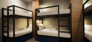 Zimmer mit 2 Etagenbetten mit weißer Bettwäsche in der Unterkunft Tido Hostel Penang in George Town