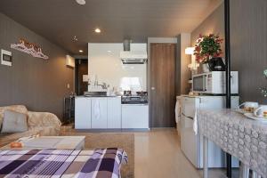 Il comprend une cuisine et un salon avec des appareils électroménagers blancs. dans l'établissement Akabane TK Building 301, à Tokyo