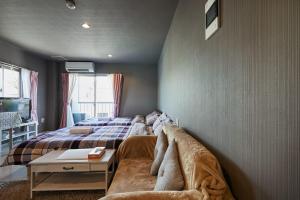 a bedroom with a couch next to a bed at Akabane TK Building 301 in Tokyo