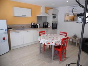 a kitchen with a table and red chairs in a kitchen at LE PRESSOIR in Mercurol