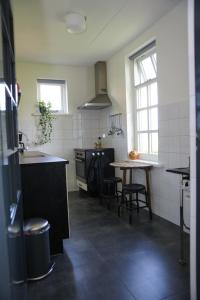 eine Küche mit einem Tisch, einem Waschbecken und einem Tisch in der Unterkunft Gastenverblijf Eenigenburg in Eenigenburg